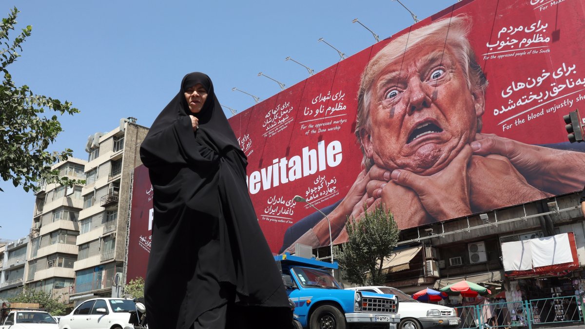 A woman walks next to an anti-Trump billboard, Tehran, Iran, Aug. 19, 2026. (EPA Photo)