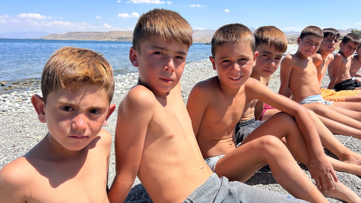 Children sit on the shore of Lake Van, eastern Türkiye, Aug. 21, 2026. (İHA Photo)