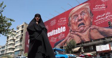 A woman walks next to an anti-Trump billboard, Tehran, Iran, Aug. 19, 2026. (EPA Photo)