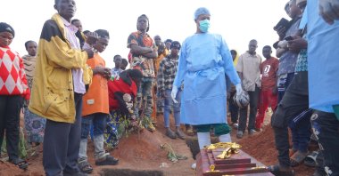 Mourners gather around the coffin of Baudo Baraka Jules as a person wearing protective clothing stands nearby during his burial at Nyamurongo Cemetery, Bunia, DRC, Aug. 18, 2026. (EPA Photo)