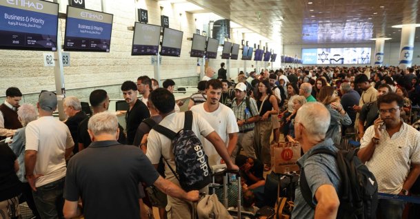 Passengers wait with their luggage at a check-in area amid disruptions caused by a surprise staff strike at Ben Gurion Airport in Lod, near Tel Aviv, Aug. 20, 2026. (AFP File Photo)