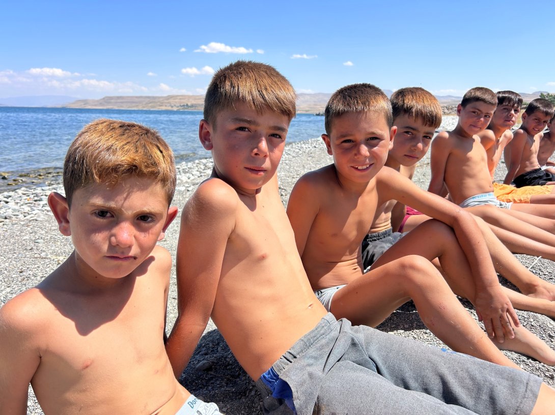 Children sit on the shore of Lake Van, eastern Türkiye, Aug. 21, 2026. (İHA Photo)