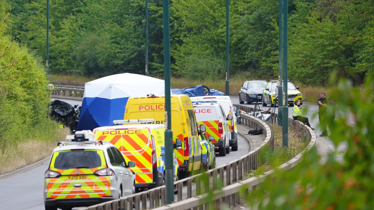 Police officers at the scene of a fatal crash involving a police car and a Volkswagen Passat on the A66 in South Bank, Middlesbrough, U.K., Aug. 22, 2026. (AP Photo)
