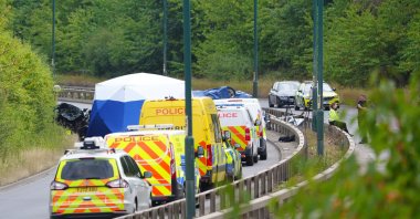 Police officers at the scene of a fatal crash involving a police car and a Volkswagen Passat on the A66 in South Bank, Middlesbrough, U.K., Aug. 22, 2026. (AP Photo)