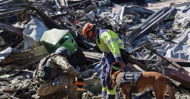 Rescuers with a dog work at a site of a shopping centre destroyed by yesterday's Russian drone attack, amid Russia's attack on Ukraine, in the city of Kryvyi Rih, Dnipropetrovsk region, Ukraine, Aug. 22, 2026. (Reuters Photo)