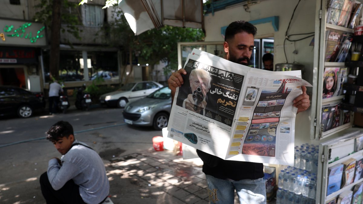 An Iranian man reads a copy of the Iranian daily newspaper Hamshahri displaying a picture of U.S. President Donald Trump and a title reading in Persian, "The empty gun of sanctions," reporting the new harsh economic threat by Trump against Iran, outside a kiosk in Tehran, Iran, Aug. 22, 2026. (EPA Photo)