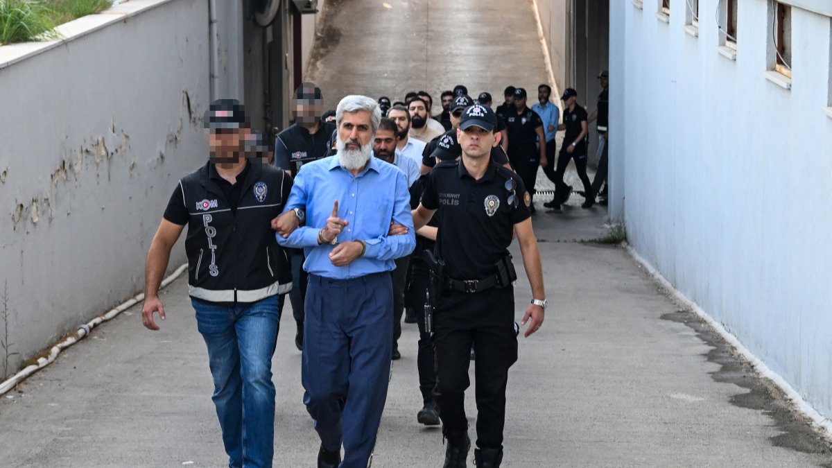 Police officers escort Alparslan Kuytul to the courthouse after his detention, Adana, southern Türkiye, Aug. 22, 2026. (AA Photo)