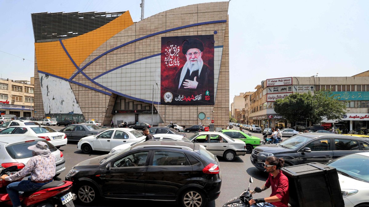 Motorists drive vehicles past a billboard depicting Iran's late supreme leader Ali Khamenei along a street, central Tehran, Iran, Aug. 8, 2026. (AFP Photo)