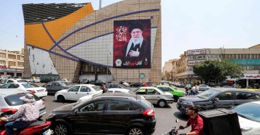 Motorists drive vehicles past a billboard depicting Iran's late supreme leader Ali Khamenei along a street, central Tehran, Iran, Aug. 8, 2026. (AFP Photo)