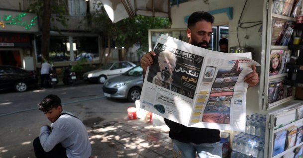 An Iranian man reads a copy of the Iranian daily newspaper Hamshahri displaying a picture of U.S. President Donald Trump and a title reading in Persian, "The empty gun of sanctions," reporting the new harsh economic threat by Trump against Iran, outside a kiosk in Tehran, Iran, Aug. 22, 2026. (EPA Photo)