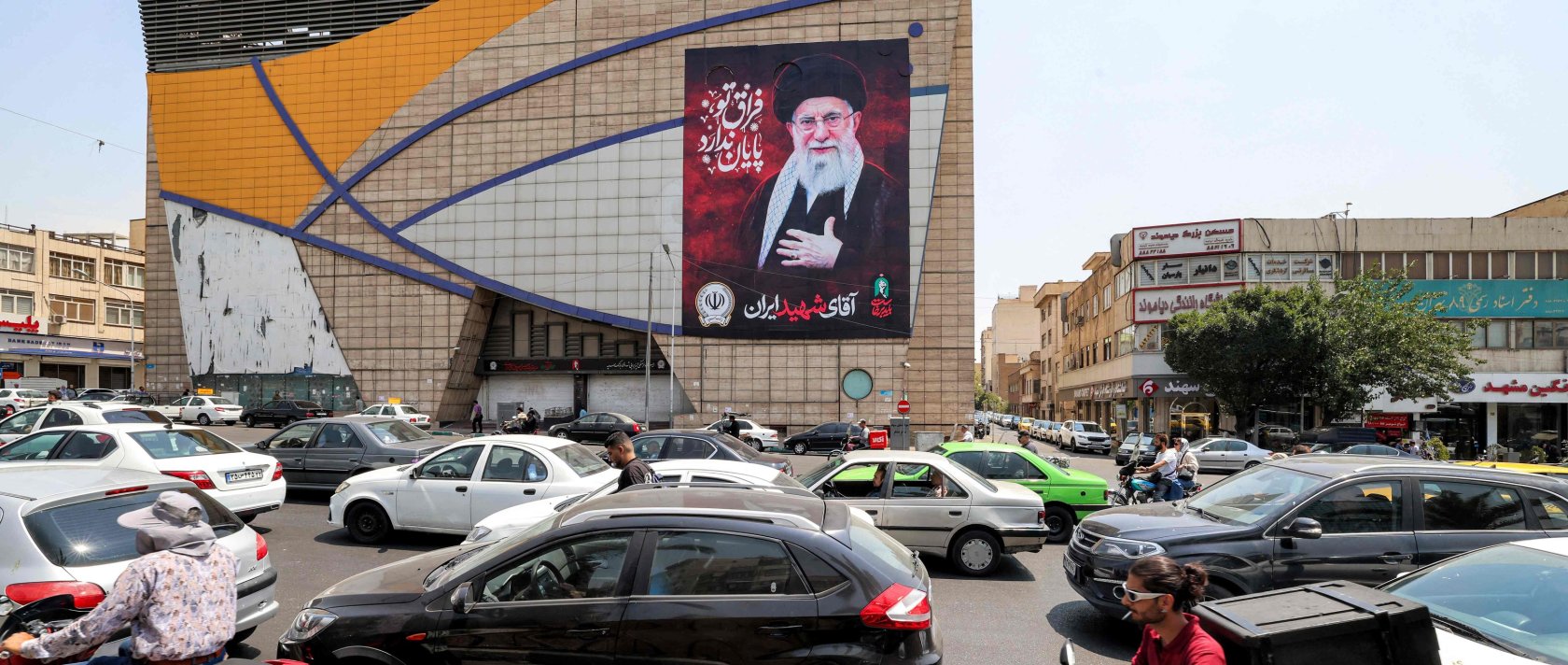Motorists drive vehicles past a billboard depicting Iran's late supreme leader Ali Khamenei along a street, central Tehran, Iran, Aug. 8, 2026. (AFP Photo)