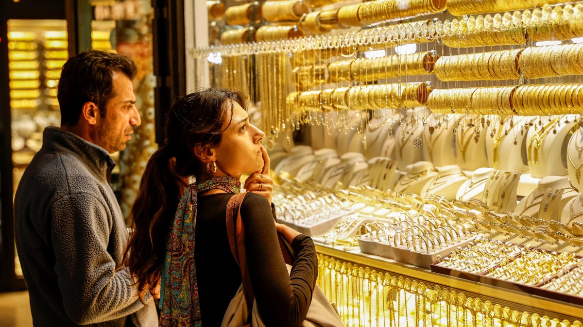 People look at gold jewelry as they stand outside a jewelry shop at the Grand Bazaar in Istanbul, Türkiye, Jan. 26, 2026. (Reuters Photo)
