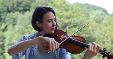 American violinist and ethnomusicologist Audrey Wozniak plays the violin while exploring Türkiye’s musical traditions in Rize, northern Türkiye, Aug. 21, 2026. (AA Photo)