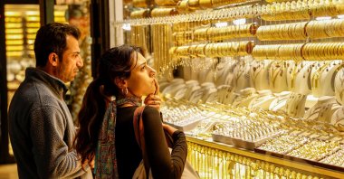 People look at gold jewelry as they stand outside a jewelry shop at the Grand Bazaar in Istanbul, Türkiye, Jan. 26, 2026. (Reuters Photo)