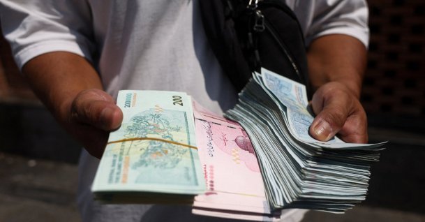 A currency dealer holds Iranian rial in the Grand Bazaar in Tehran, Iran, Aug. 17, 2026. (Reuters Photo)