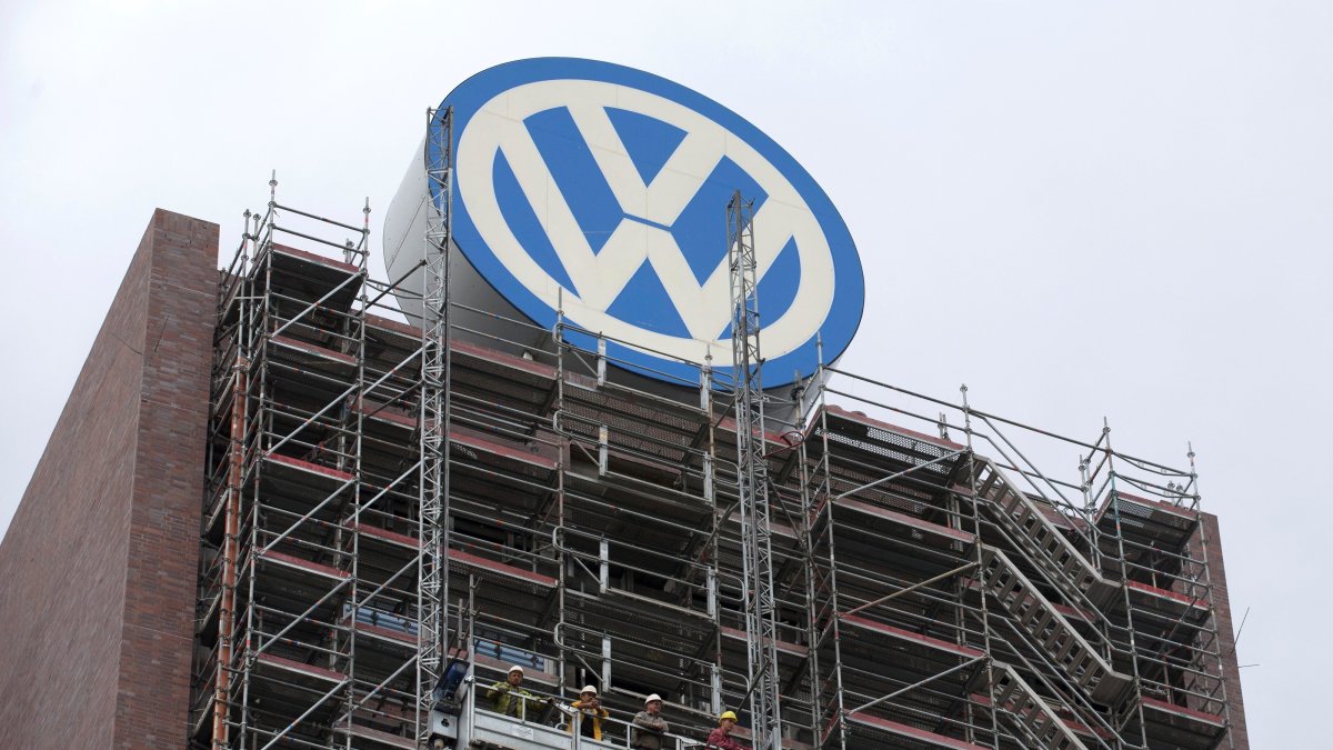 Employees stand on scaffolding below the Volkswagen logo on the roof of the company's headquarters, Wolfsburg, Germany, Sept. 22, 2015. (Reuters Photo)