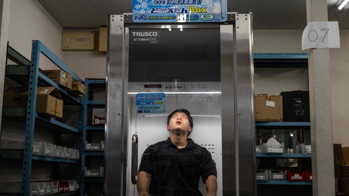 Konoe employee Taichi Konishi takes a break in a cooling box for workers also known as a "human fridge" at the company's warehouse, a specialist wholesaler of screws and surveying equipment, on a hot day in Higashiosaka, Osaka Prefecture, Japan, Aug. 21, 2026. (AFP Photo)