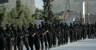 Kurdish fighters from the Qamishli Brigade, part of the Syrian Democratic Forces (SDF) participate in a military parade in Qamishli on August 21, 2026, during the funeral ceremony for three Kurdish fighters killed in previous battles in Aleppo's Sheikh Maqsoud neighbourhood in the north of Syria. (Photo by Delil SOULEIMAN / AFP)