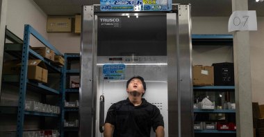 Konoe employee Taichi Konishi takes a break in a cooling box for workers also known as a "human fridge" at the company's warehouse, a specialist wholesaler of screws and surveying equipment, on a hot day in Higashiosaka, Osaka Prefecture, Japan, Aug. 21, 2026. (AFP Photo)