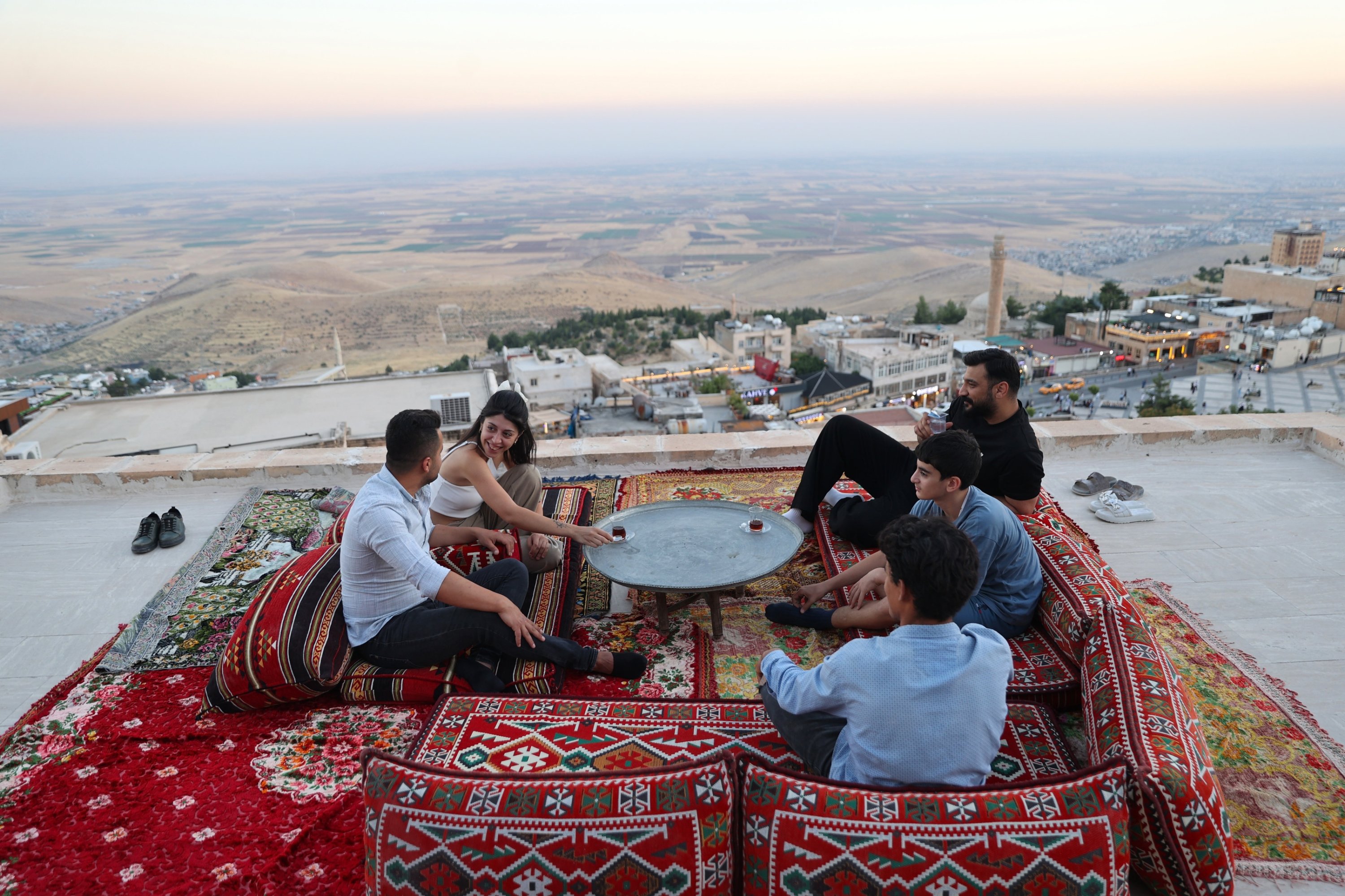 Residents gather on a traditional rooftop platform to drink tea and socialize, Mardin, southeastern Türkiye, Aug. 4, 2026. (AA Photo)
