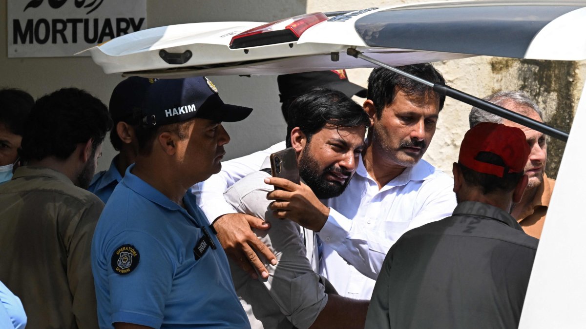 A man consoles a grieving father (C) as his child's coffin is carried after a fire outside the Pakistan Institute of Medical Sciences (PIMS) Hospital in Islamabad, Pakistan, Aug. 26, 2026. (AFP Photo)