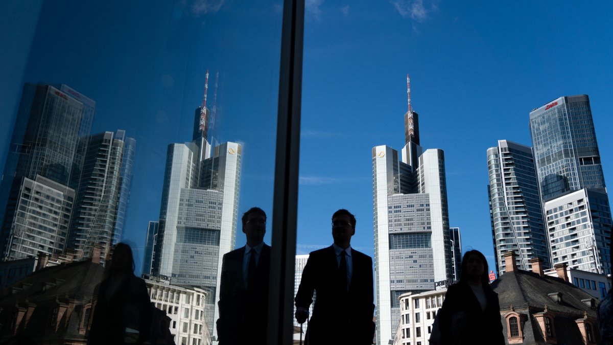 People walking past the Commerzbank headquarters are reflected in a window in the banking district in Frankfurt am Main, Germany, Aug. 20, 2026. (EPA Photo)