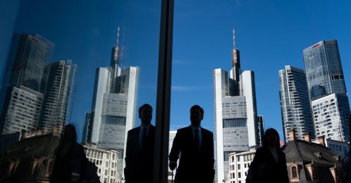 People walking past the Commerzbank headquarters are reflected in a window in the banking district in Frankfurt am Main, Germany, Aug. 20, 2026. (EPA Photo)