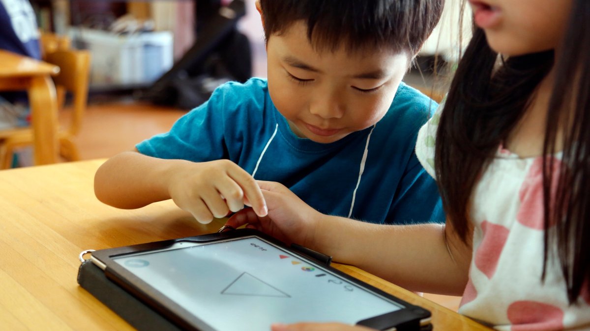 Children work on a digital program at Coby Preschool in Yoshikawa, Tokyo, Japan, July 12, 2018. (AP Photo)