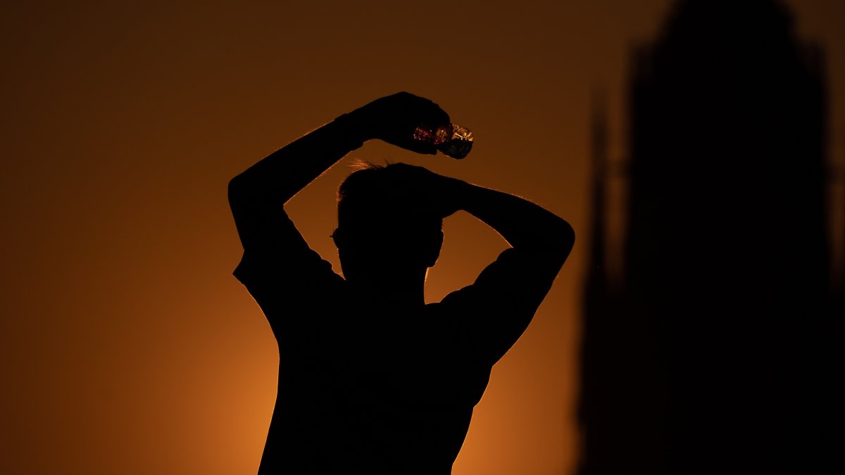A person holds a plastic bottle at sunset amid a heat wave in Frankfurt am Main, Germany, July 30, 2026. (EPA Photo)