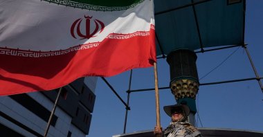 A woman flies an Iranian flag in downtown Tehran, Iran, Monday, Aug. 17, 2026. (AP Photo)