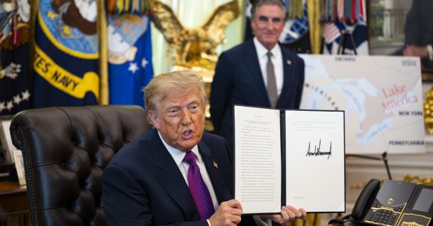 U.S. President Donald Trump shows a signed executive order to rename Lake Ontario as Lake America, amid a recent trade war, in the Oval Office of the White House in Washington, D.C., Aug. 2026. (EPA Photo)