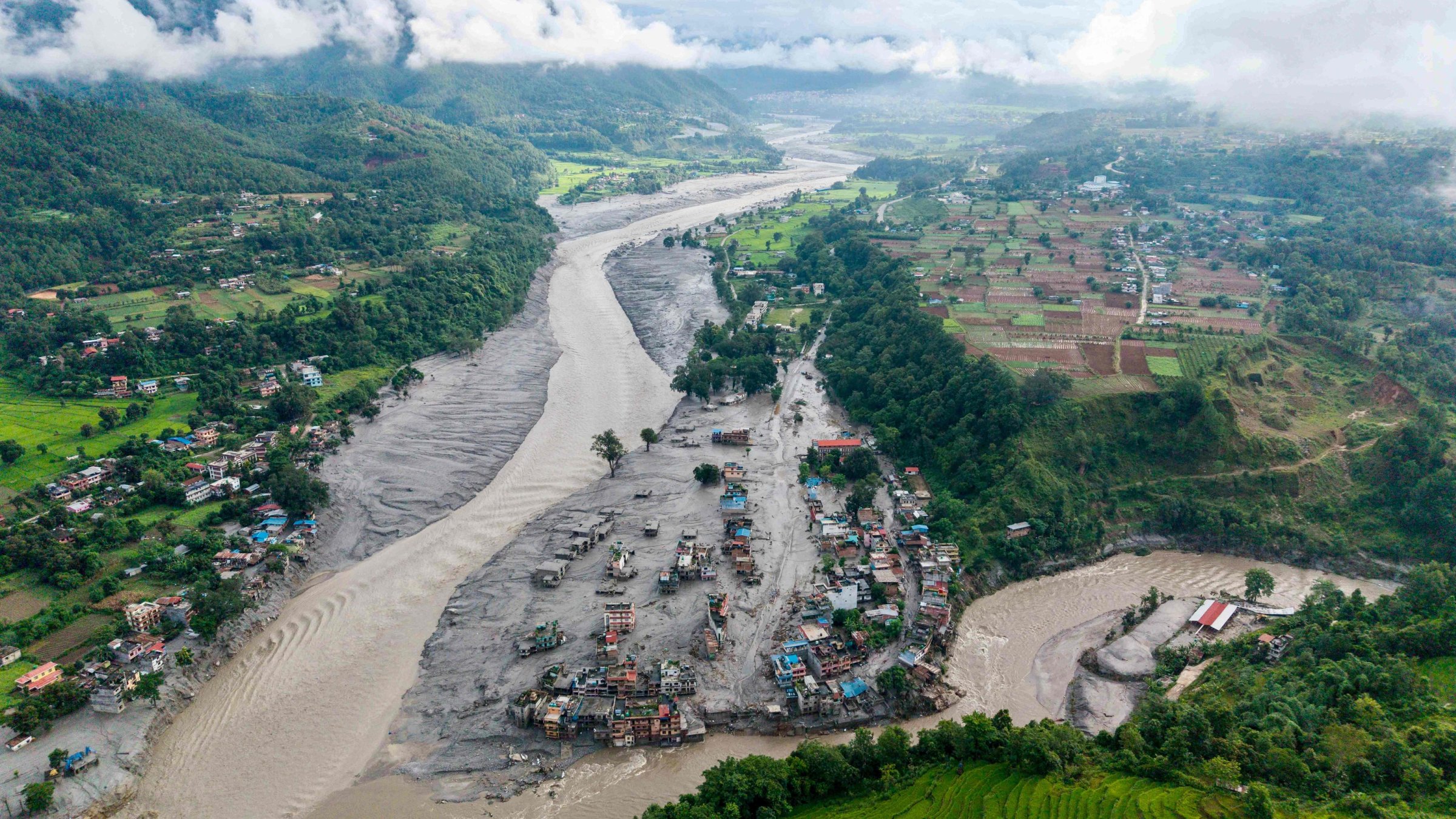 An aerial view shows houses inundated with sludge after flash floods in Devighat, Bidur Municipality, along the confluence of the Trishuli and Tadi rivers, Nuwakot District, Nepal, Aug. 27, 2026. (AFP Photo)