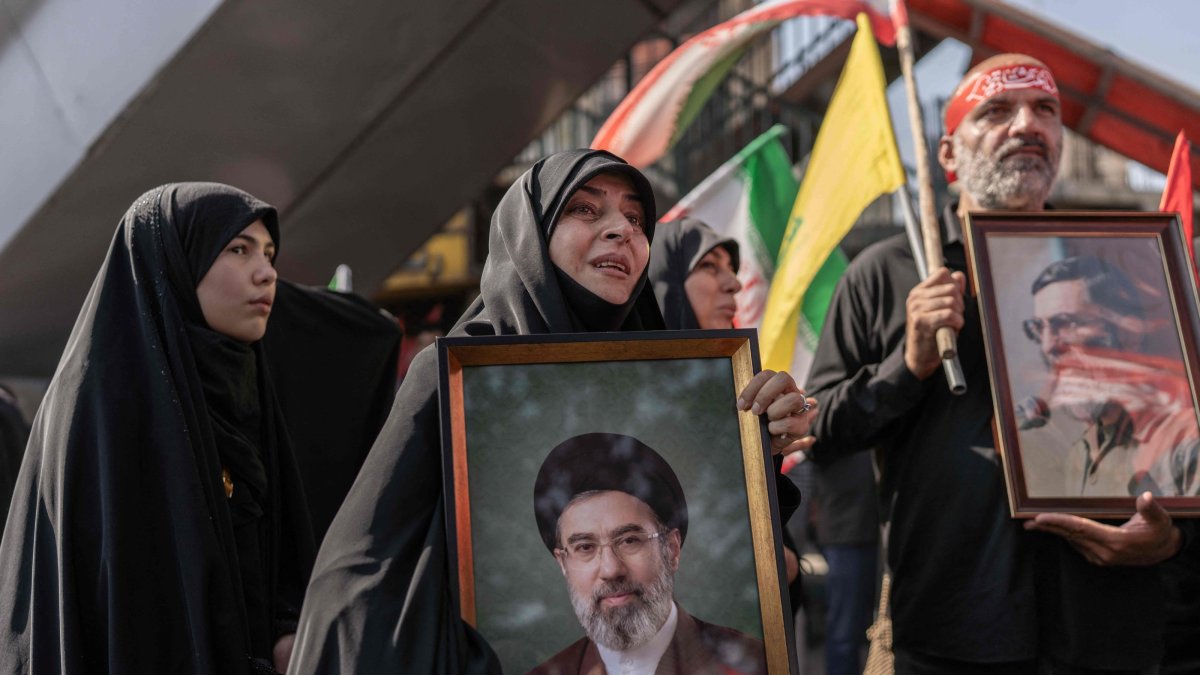 (FILES) A mourner holds a portrait of Iran's supreme leader Ayatollah Mojtaba Khamenei as people attend the funeral procession of Iran's slain supreme leader Ayatollah Ali Khamenei and his family members, Tehran, Iran, July 6, 2026. (AFP Photo)