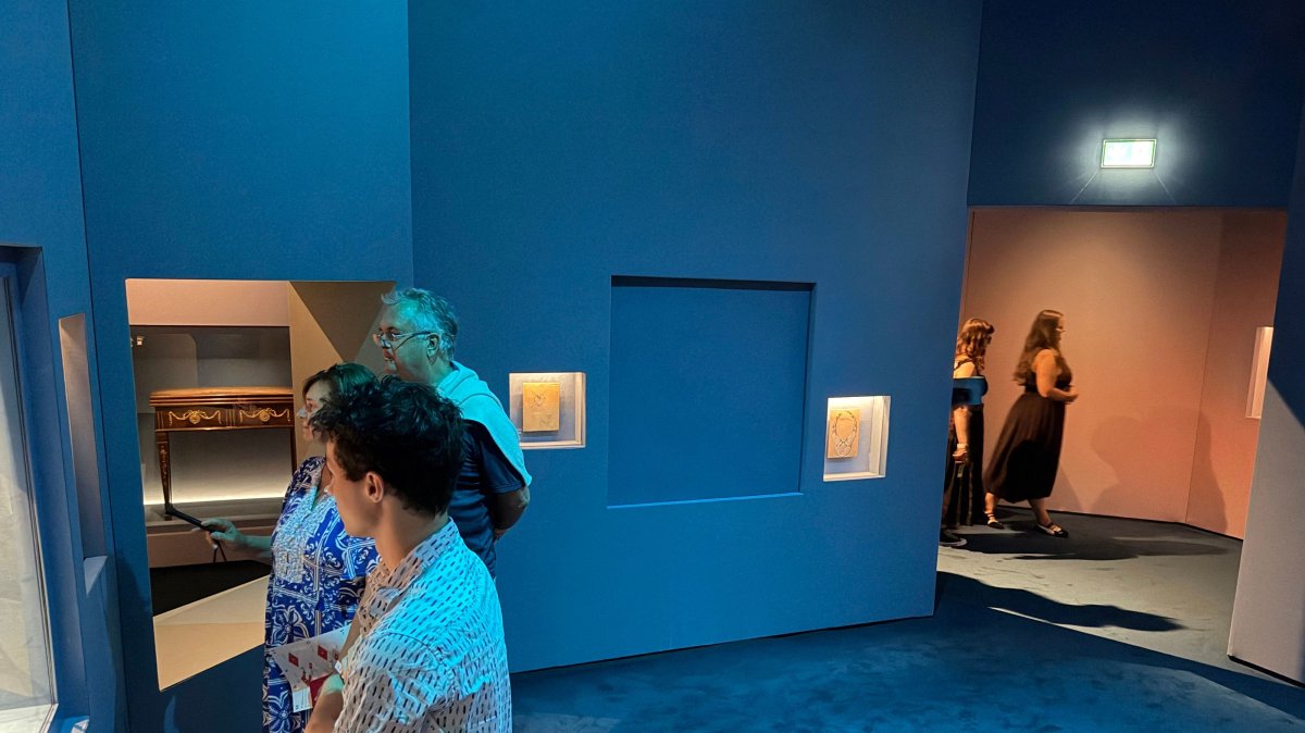 Visitors look at exhibits near a blue panel covering the area where a display case was smashed, and a Van Cleef and Arpels necklace was stolen at Vienna's Museum of Applied Arts (MAK), Vienna, Austria, Aug. 28, 2026. (AFP Photo)