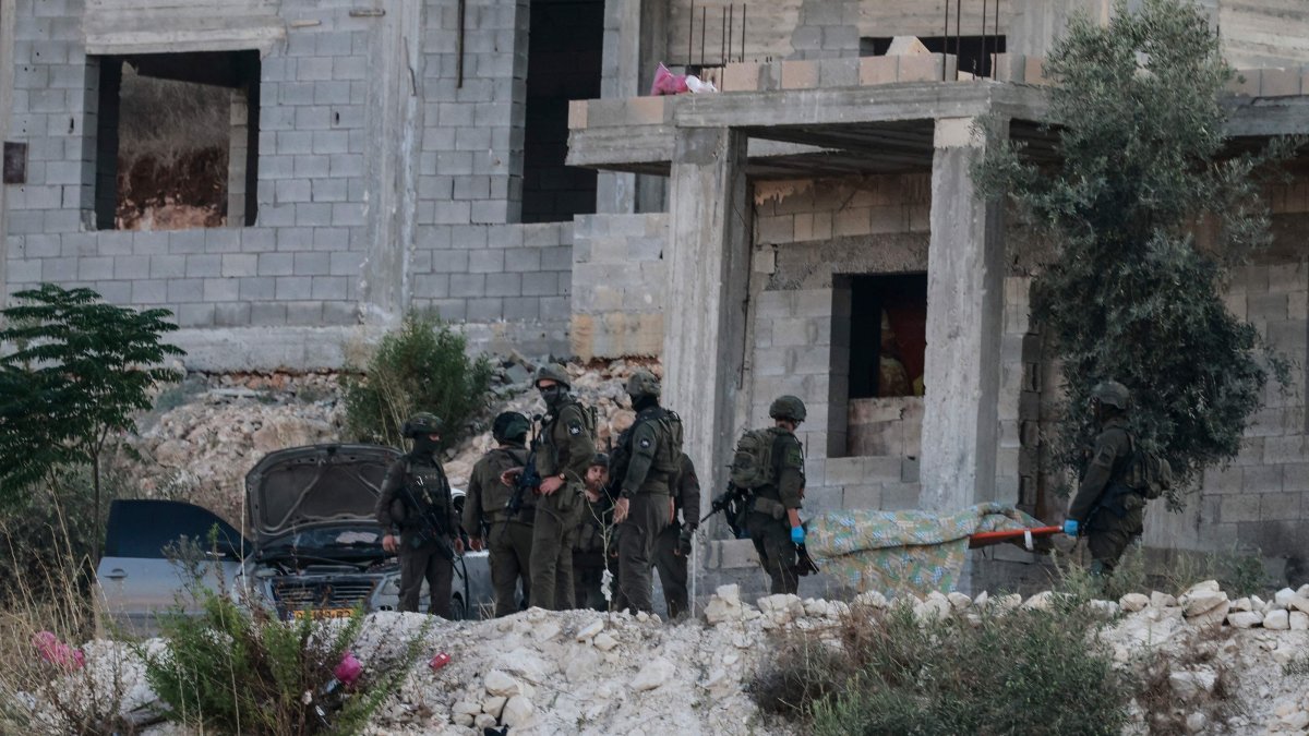 Israeli soldiers remove the body of a Palestinian from a house under construction, on the western outskirts of the northern city of Jenin, in the Israeli-occupied West Bank, Aug. 28, 2026. (AFP Photo)