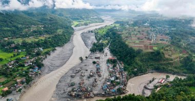 An aerial view shows houses inundated with sludge after flash floods in Devighat, Bidur Municipality, along the confluence of the Trishuli and Tadi rivers, Nuwakot District, Nepal, Aug. 27, 2026. (AFP Photo)