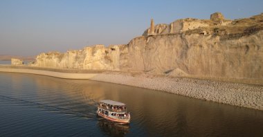 An aerial view shows a tour boat on the Ilısu Dam reservoir in Hasankeyf, Batman, southeastern Türkiye, Aug. 23, 2026. (AA Photo)