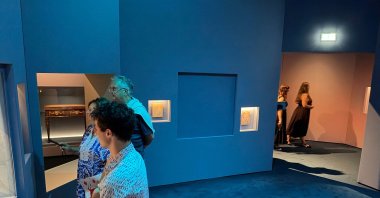 Visitors look at exhibits near a blue panel covering the area where a display case was smashed, and a Van Cleef and Arpels necklace was stolen at Vienna's Museum of Applied Arts (MAK), Vienna, Austria, Aug. 28, 2026. (AFP Photo)
