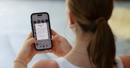 A teenager poses holding a mobile phone in Sydney, Australia, Dec. 10, 2025. (Reuters Photo)
