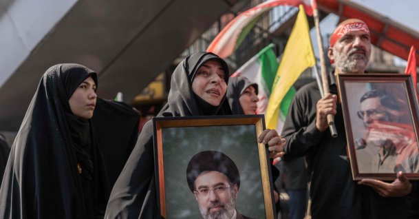 (FILES) A mourner holds a portrait of Iran's supreme leader Ayatollah Mojtaba Khamenei as people attend the funeral procession of Iran's slain supreme leader Ayatollah Ali Khamenei and his family members, Tehran, Iran, July 6, 2026. (AFP Photo)