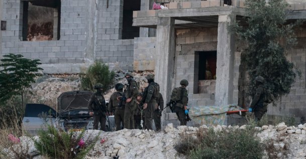 Israeli soldiers remove the body of a Palestinian from a house under construction, on the western outskirts of the northern city of Jenin, in the Israeli-occupied West Bank, Aug. 28, 2026. (AFP Photo)