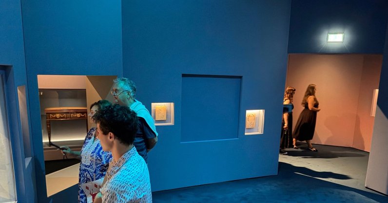 Visitors look at exhibits near a blue panel covering the area where a display case was smashed, and a Van Cleef and Arpels necklace was stolen at Vienna's Museum of Applied Arts (MAK), Vienna, Austria, Aug. 28, 2026. (AFP Photo)