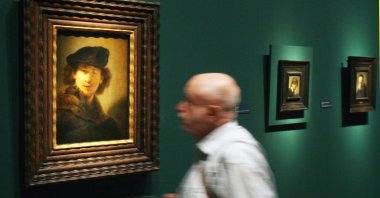 A man looks at a self-portrait by the famous Dutch painter Rembrandt while attending the exhibition "Rembrandt. Quest of a Genius," Berlin, Germany, Aug. 3, 2006. (Getty Images Photo)