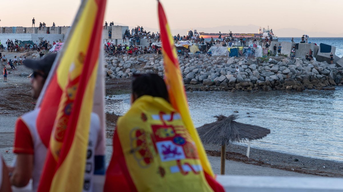 Anti-migrant demonstrators look toward migrants camping on the Trampolin beach in Ceuta, Spain, Aug. 28, 2026. (AFP Photo)