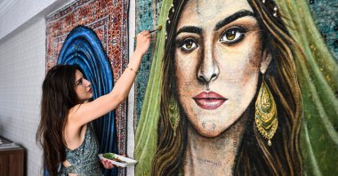 Computer engineer and artist Gizem Aytaç paints a portrait on a carpet, Elazığ, eastern Türkiye, Aug. 27, 2026. (AA Photo)