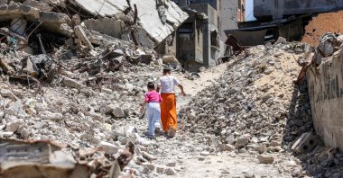 Two girls walk past the rubble of buildings destroyed in Israeli attacks in Khan Younis, southern Gaza Strip, Palestine, Aug. 25, 2026. (AFP Photo)