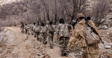 PJAK terrorists are seen walking near a mountain at an unidentified location in Iran, in this undated file photo. (Photo by Afshin Ismaeli / NTB via AFP)