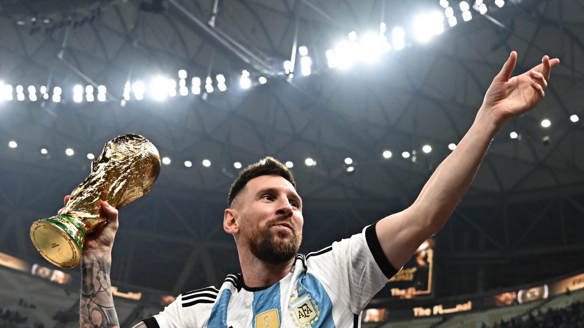 Argentina's Lionel Messi poses with the FIFA World Cup Trophy after Argentina won the Qatar 2022 World Cup final football match against France at Lusail Stadium, Lusail, Qatar, Dec. 18, 2022. (AFP Photo)