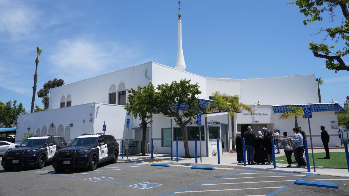 People gather as police vehicles are parked outside of the Islamic Center of San Diego, the day after a shooting, in San Diego, U.S., May 19, 2026. (AP Photo)