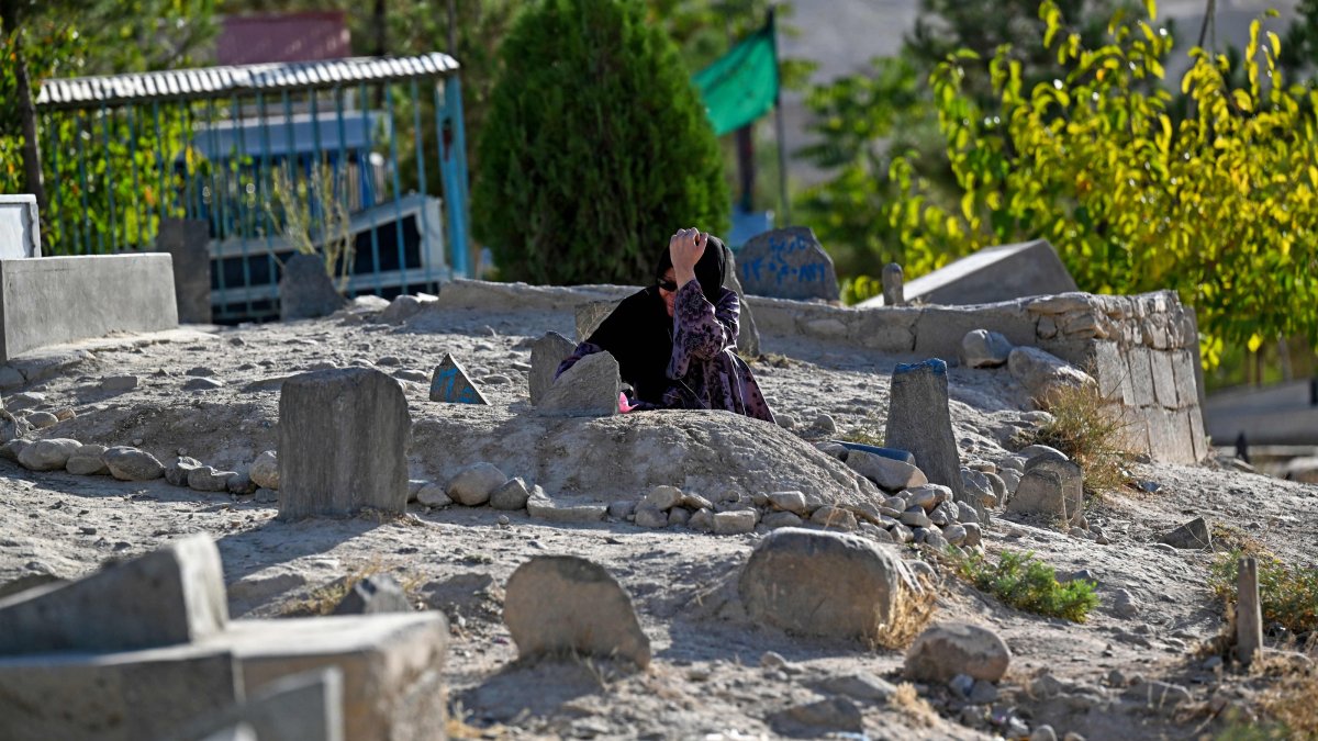 A woman pray near her relative's grave in Kabul, Afghanistan, Aug. 25, 2026. (AFP Photo)